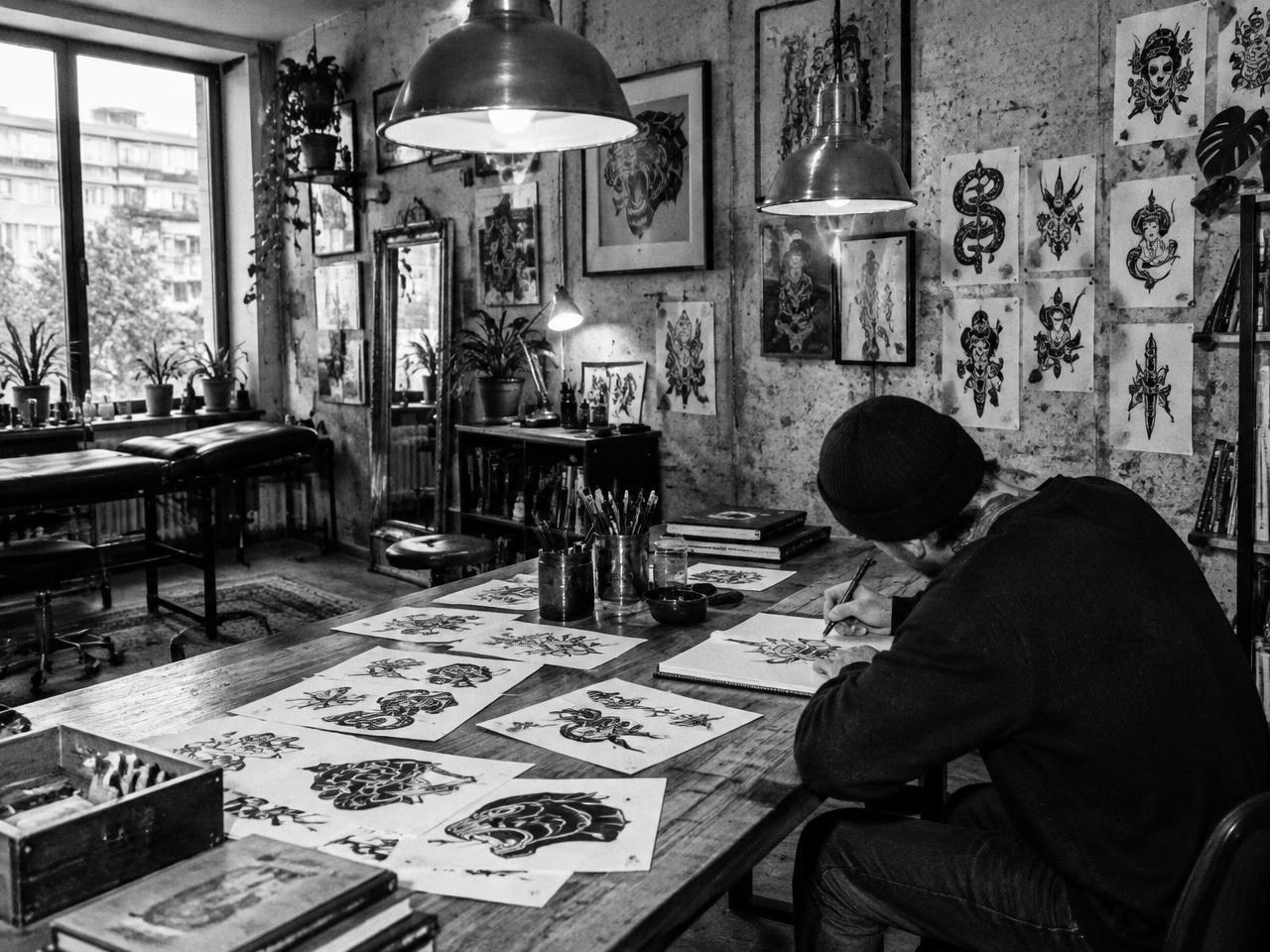 Tattoo artist drawing custom flash designs inside a Berlin studio